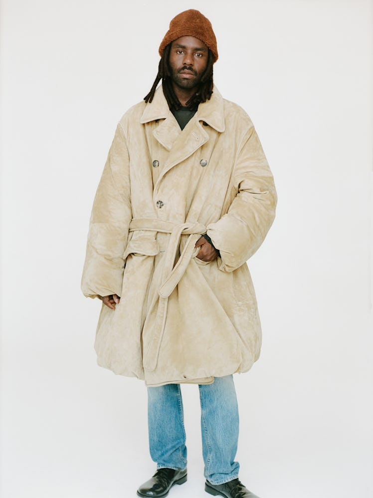Dev Hynes in trench coat.