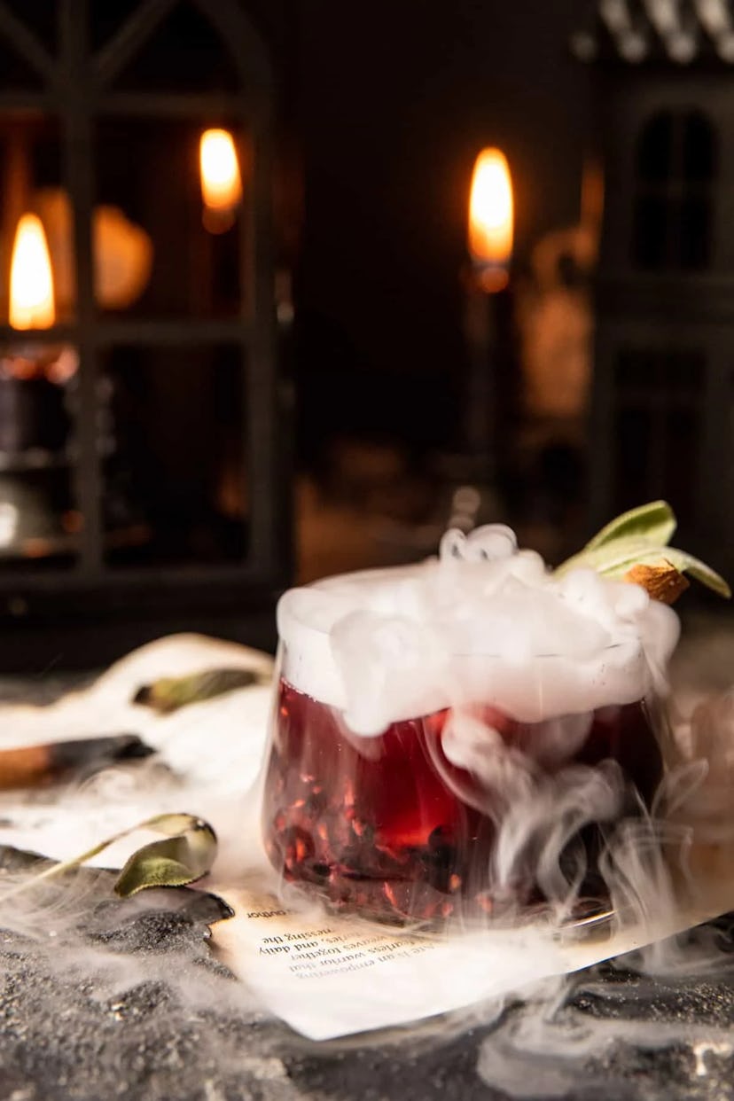 Halloween mocktail called the Sanderson Sister Smash, a dark red drink with dry ice smoke billowing ...