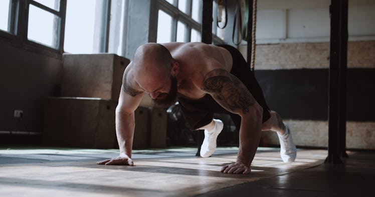 A man doing burpees at a gym.