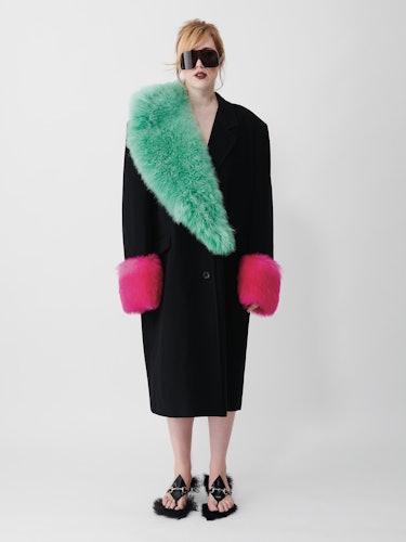 Angelica Hicks wears a black wool coat, flip-flop, green fur scarf and sunglasses.