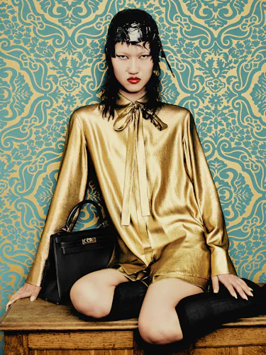 Toktorova wears a yellow blouse, sheer socks, skirt and leather bag.