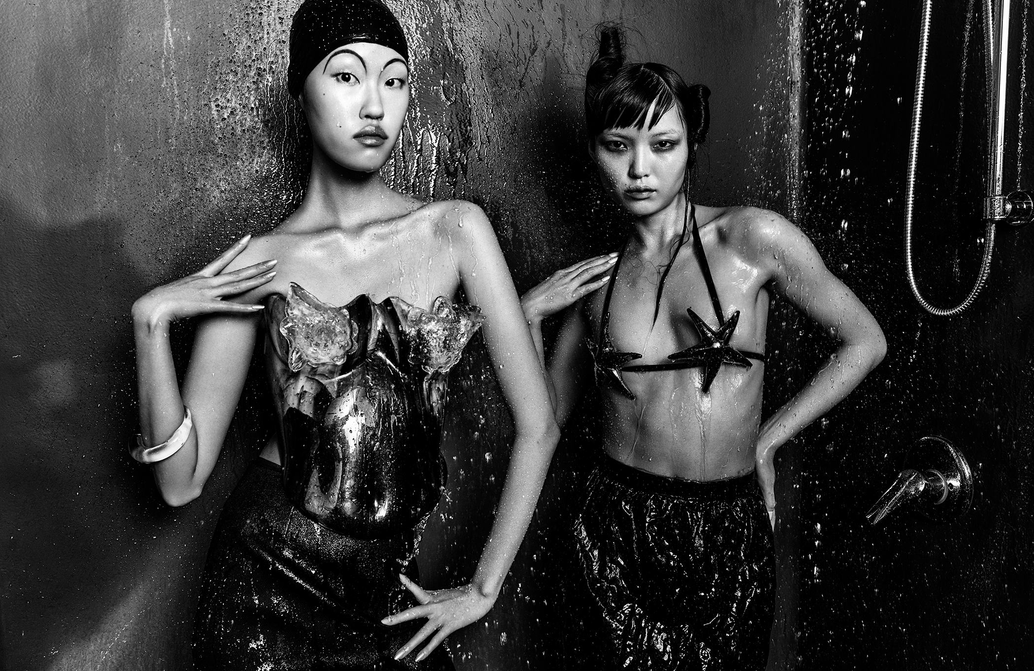 Kim wears a shiny bustier and bracelet. Jia wears a star bra and skirt.