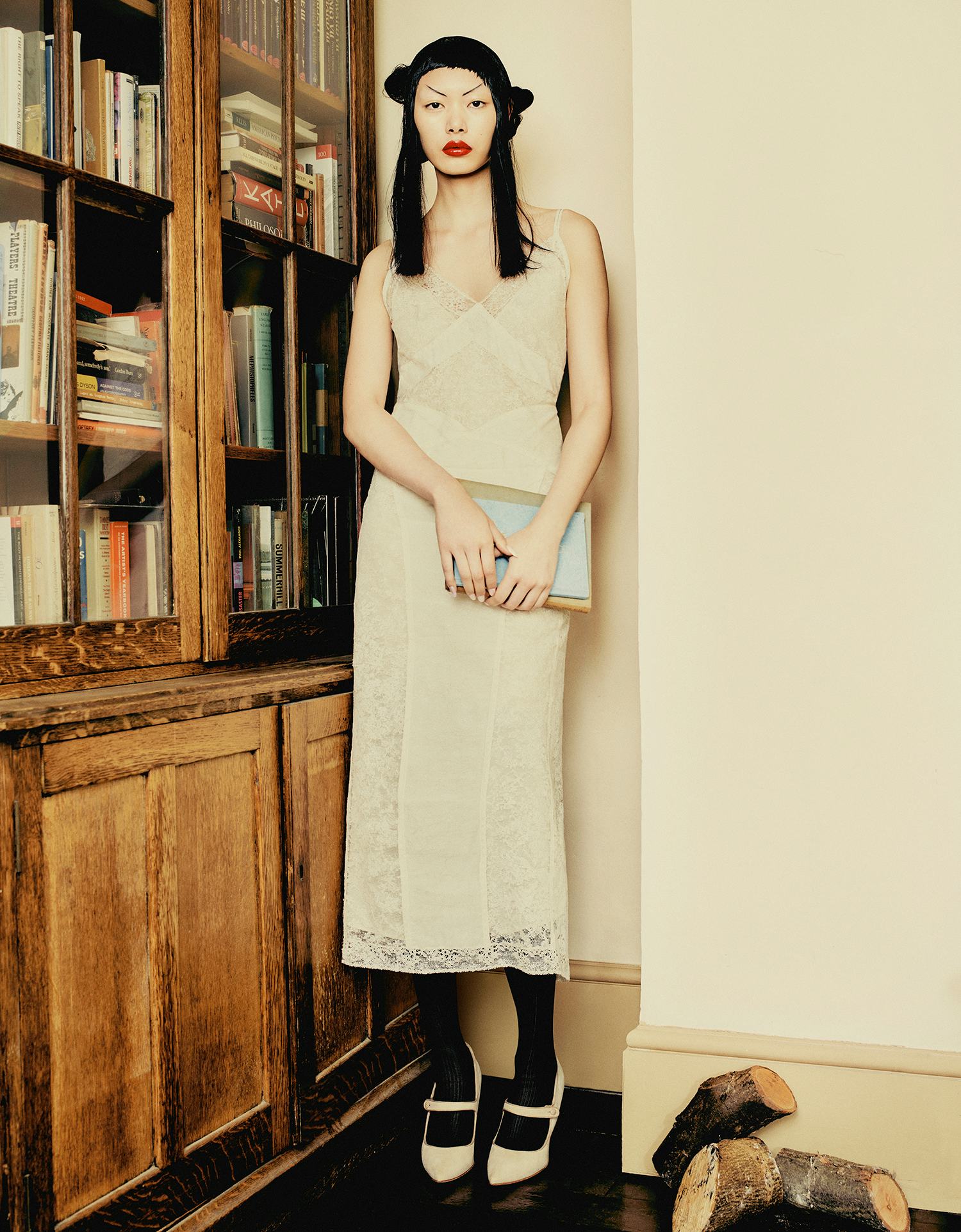 BingBing Liu wears a yellow lace dress, black tights and shoes.