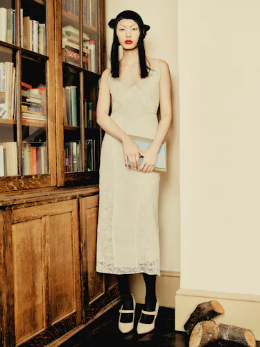BingBing Liu wears a yellow lace dress, black tights and shoes.