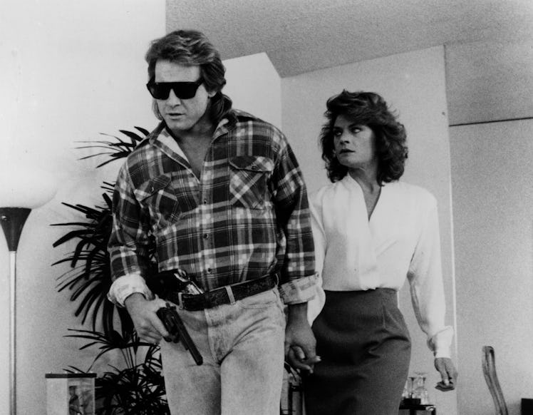 Roddy Piper and Meg Foster run from deadly alien live forces in a scene from the Universal Studio mo...