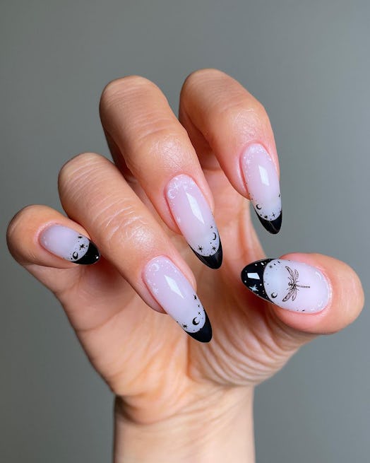 Black-tipped French nails with celestial details match the dark academia aesthetic.