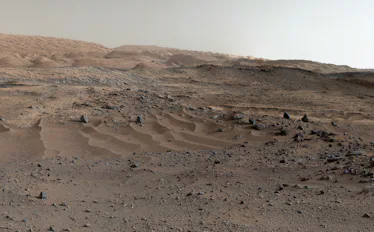 Large rocks and gravel take up most of the landscape, and more pristine-looking hills rise shallowly...