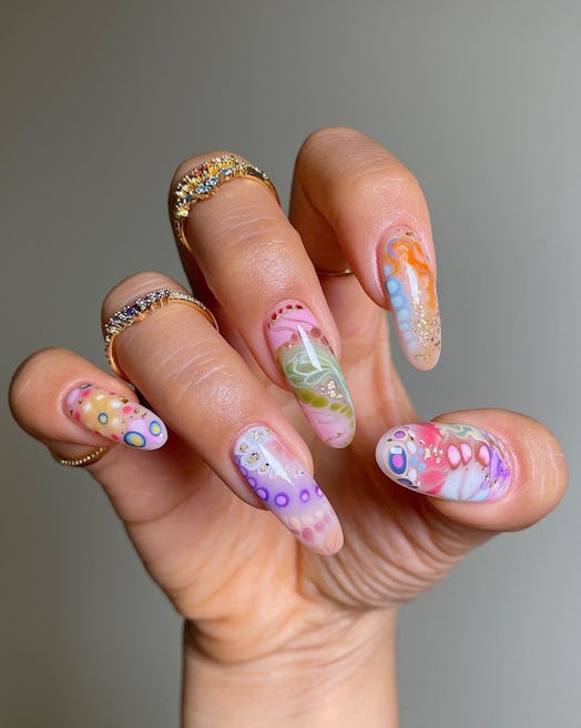 A “more is more” colorful nail art design that was created using blooming gel polish.