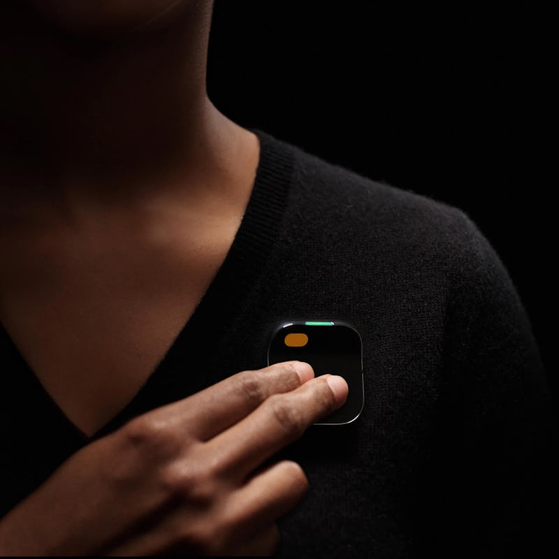 Touching the Ai Pin with two fingers.