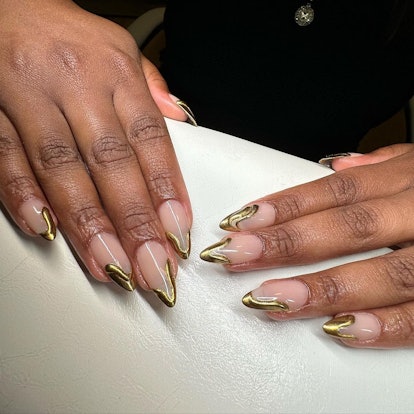3D gold chrome swirls are an on-trend Thanksgiving nail design for 2023.