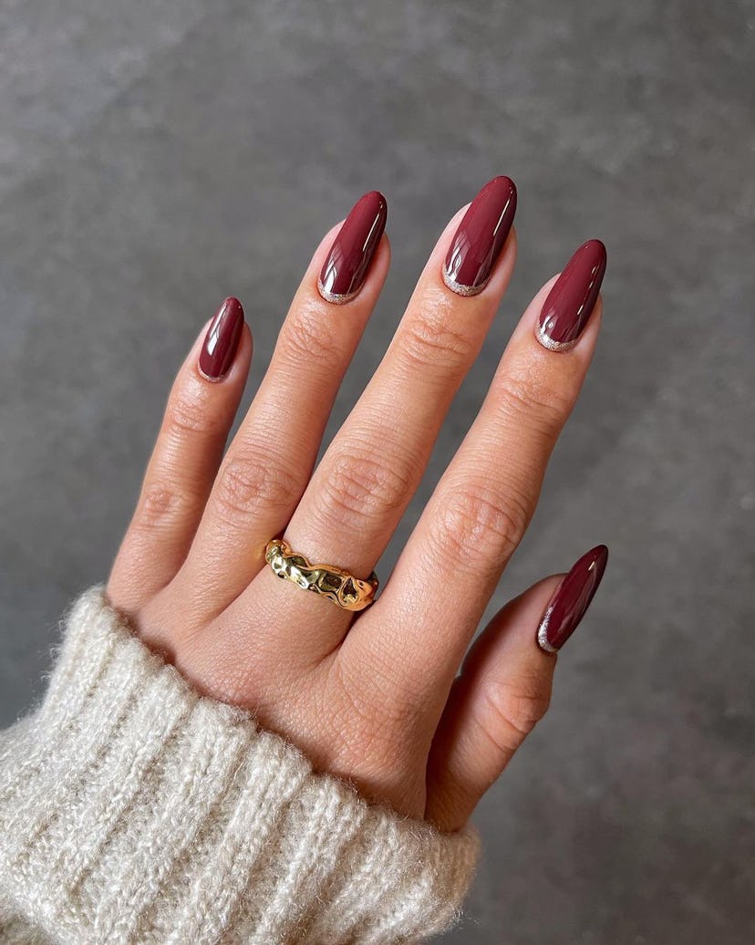 “Cherry mocha” nails with glitter cuffs are an on-trend Thanksgiving nail design 2023.
