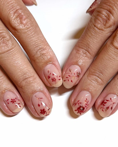 Autumnal floral designs on clear nails are an on-trend Thanksgiving 2023 nail art design.