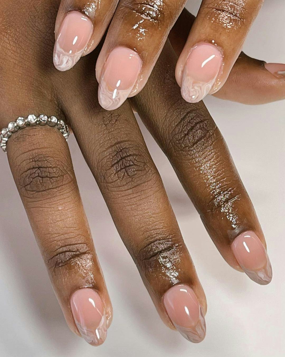 Creamy swirled French tip nails are a simple on-trend nail art design for Thanksgiving 2023.