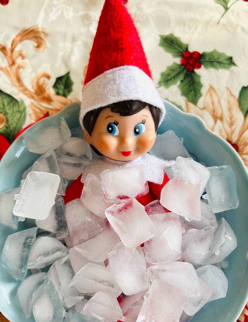 elf on the shelf sitting in a bowl of ice cubes