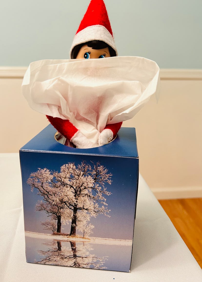 elf on the shelf hiding behind the tissues in a tissue box