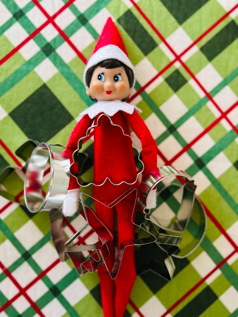 elf on the shelf holding cookie cutters