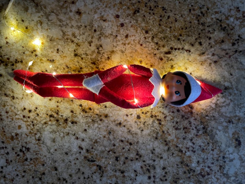 elf on the shelf wrapped in thin holiday lights