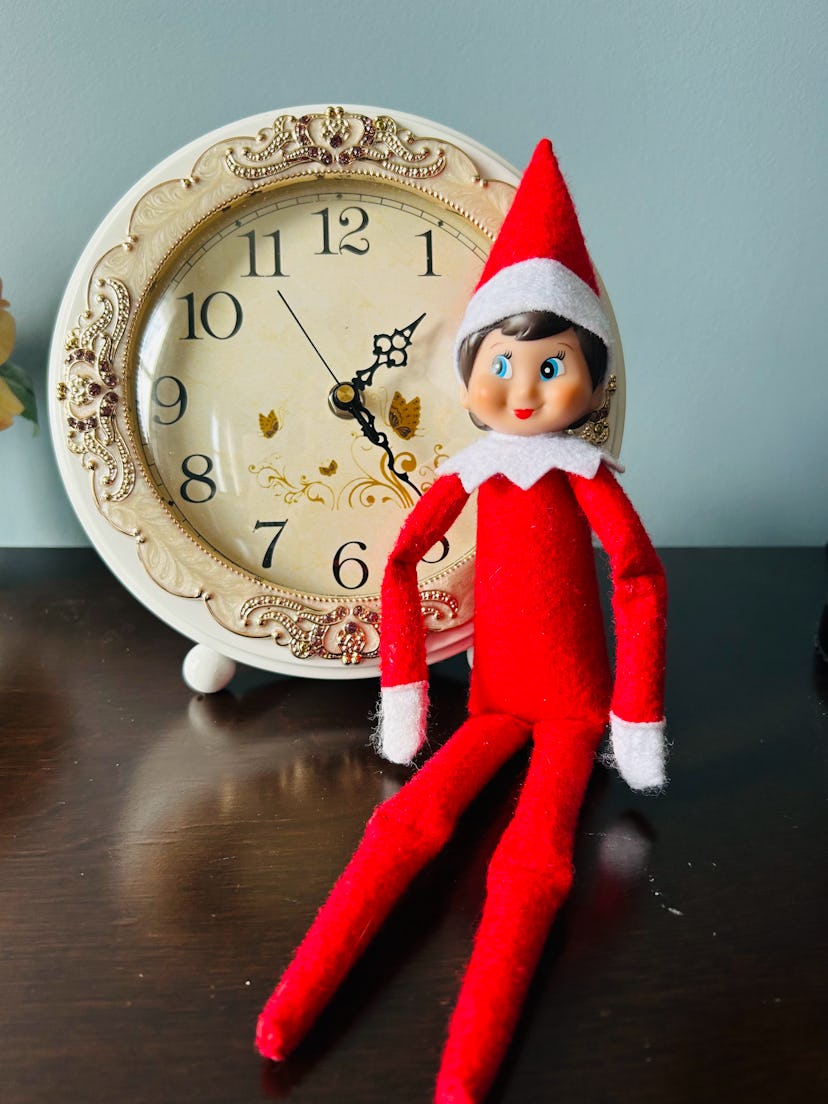 elf on the shelf in front of a ticking clock