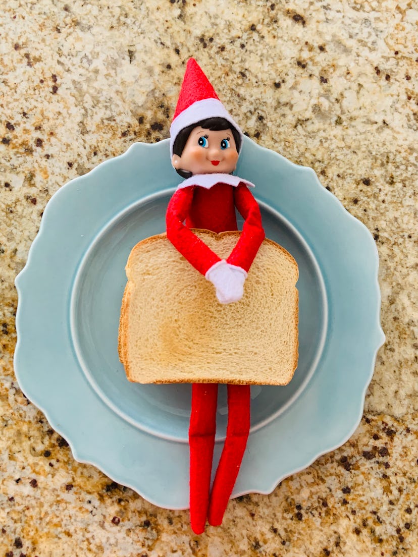 elf on the shelf holding a piece of toast