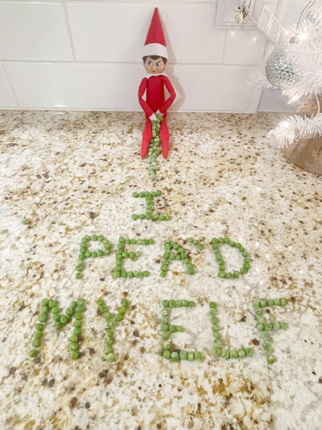 elf on the shelf with "I pea'd my elf" written in peas in front of him