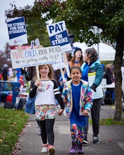 Two kids picketing with signs to support Portland teachers