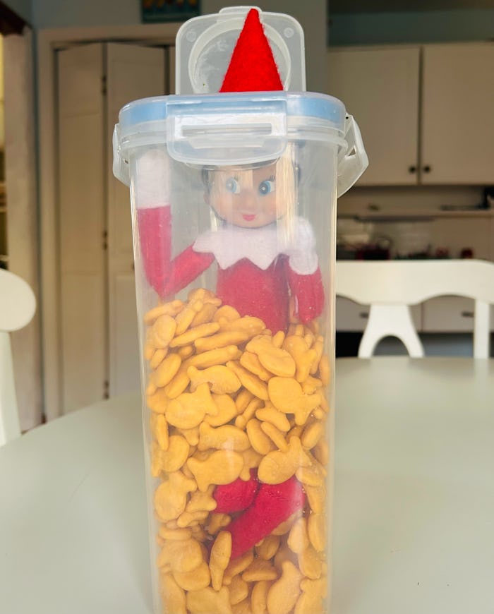 Elf on the shelf kitchen idea hiding in a snack container of goldfish crackers