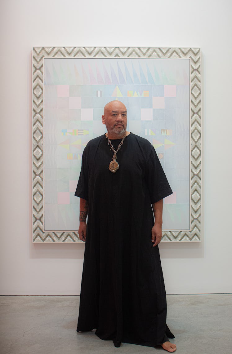 Artist Jeffrey Gibson wearing a black kaftan and gold chain.