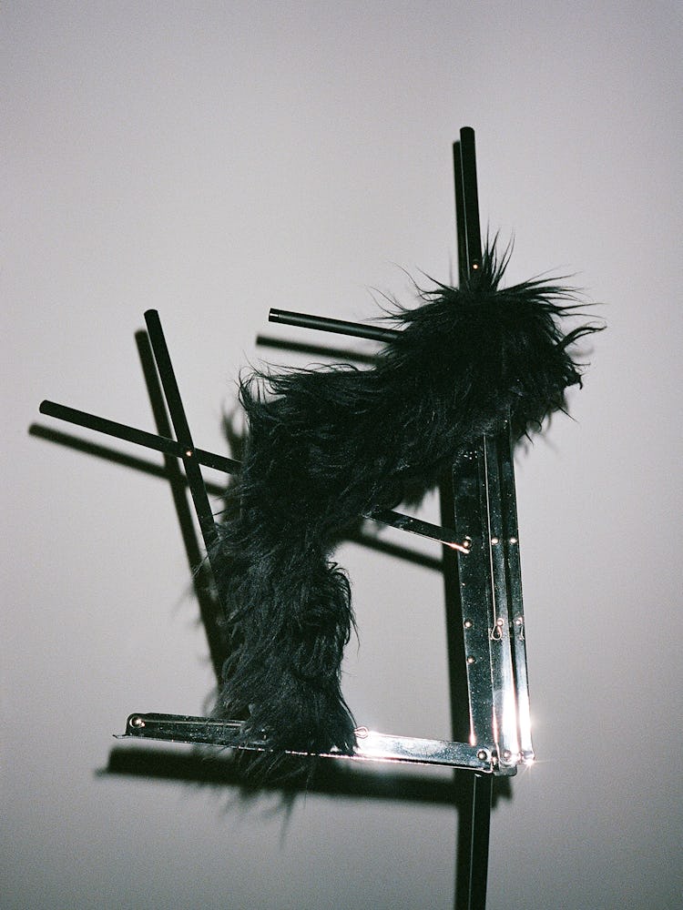 Black Fur shoes on sheet music stand.