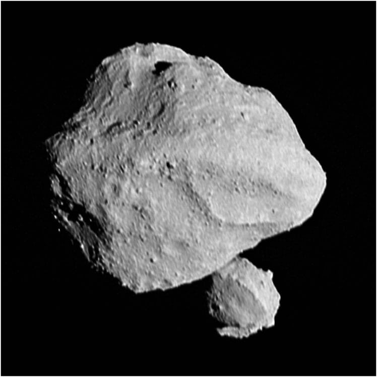 A large and roughly triangle-shaped asteroid stands in stark contrast against space, and just below ...
