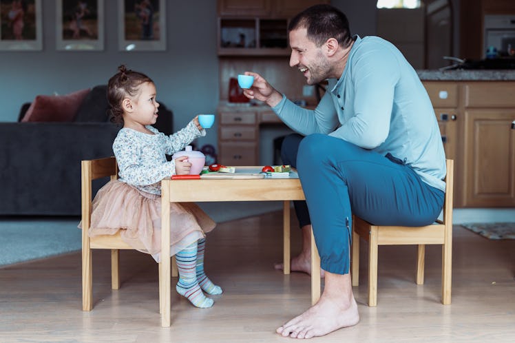 A dad having a tea party with his daughter.