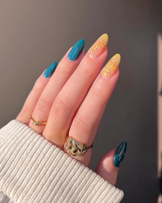 Turquoise nail polish and gold flake details are an on-trend nail design for Sagittarius season 2023...