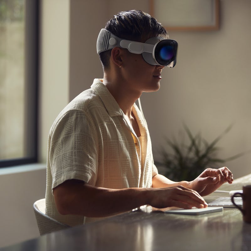 A person wearing an Apple Vision Pro at a desk.