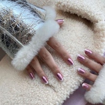 Pink chrome nails are one of winter 2024's most popular nail trends. Here, a pink chrome manicure wi...
