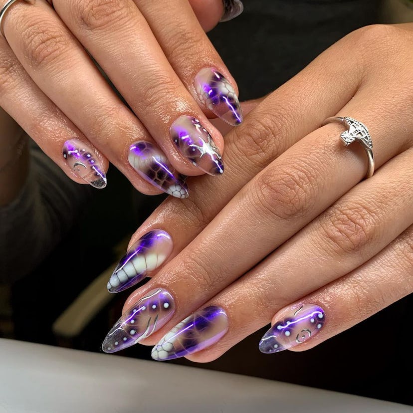 Alien-inspired nail art with neon purple nail polish colors are on-trend for Sagittarius season 2023...