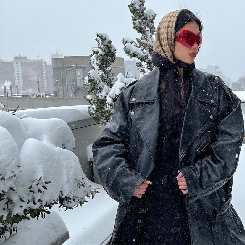 Dua Lipa in a  monogrammed Gucci scarf in the snow. 