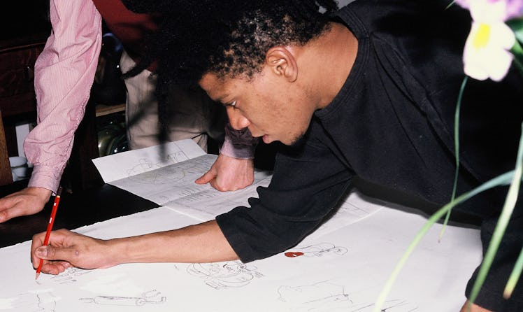 Basquiat sketching his designs.