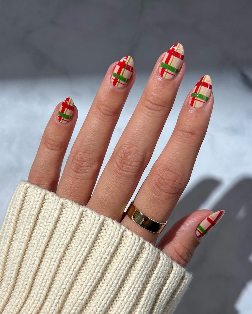 For a classy Christmas nail design for the 2023 holiday season, red and green plaid nails are festiv...