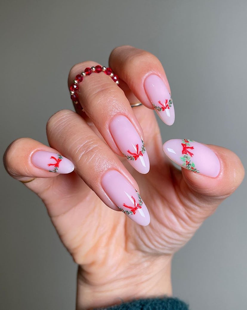 For a simple Christmas nail design for the 2023 holiday season, try a festive garland and ribbon Fre...