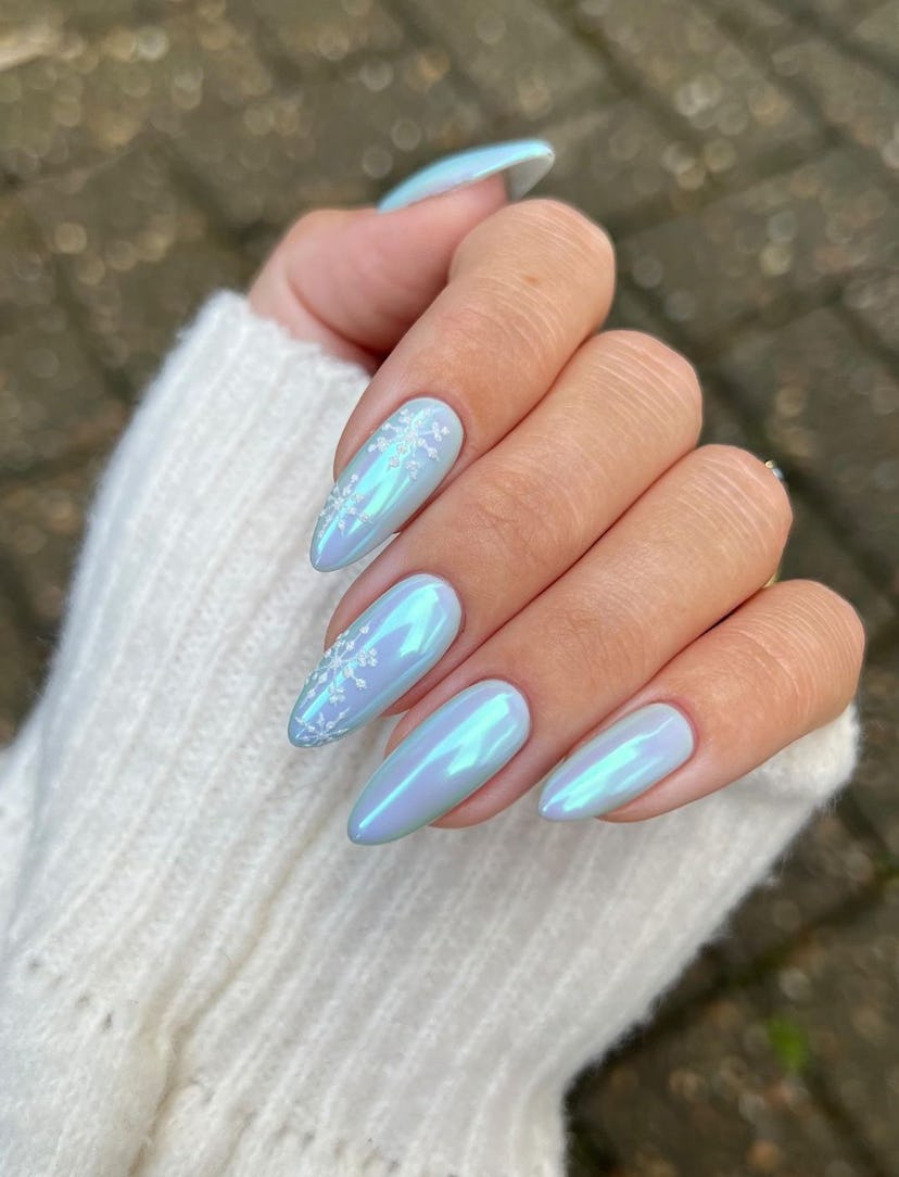 For a simple Christmas nail design for the 2023 holiday season, blue chrome nails with snowflake nai…