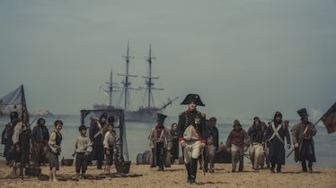 Joaquin Phoenix walks on a beach as Napoleon in 'Napoleon'