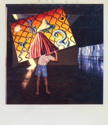 Kenny Scharf carrying a painted canvas