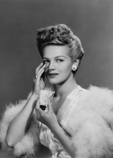 A young woman applying face cream, 1943