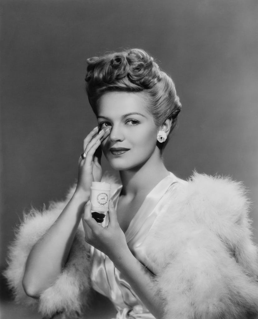 A young woman applying face cream, 1943