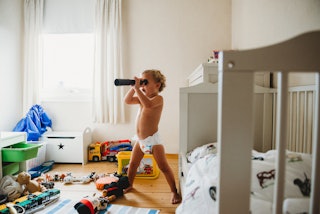 A child in a diaper plays in their room.