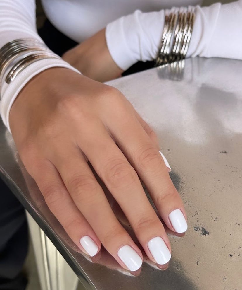 Tom Bachik paints Selena Gomez’s natural-length nails in a “milk bath” white hue, which is trending …