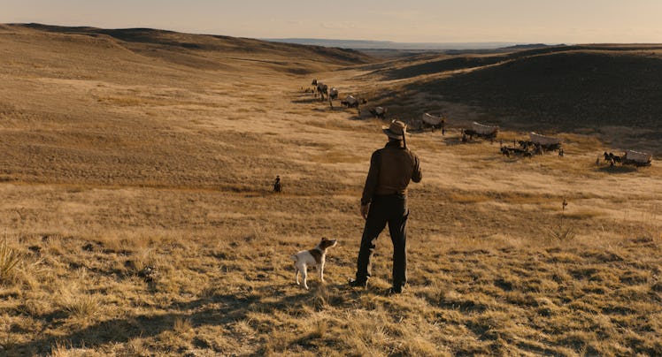 A cowboy stands next to a dog in 'The Ballad of Buster Scruggs'