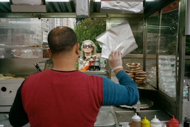 Woman orders food at a food cart in NYC