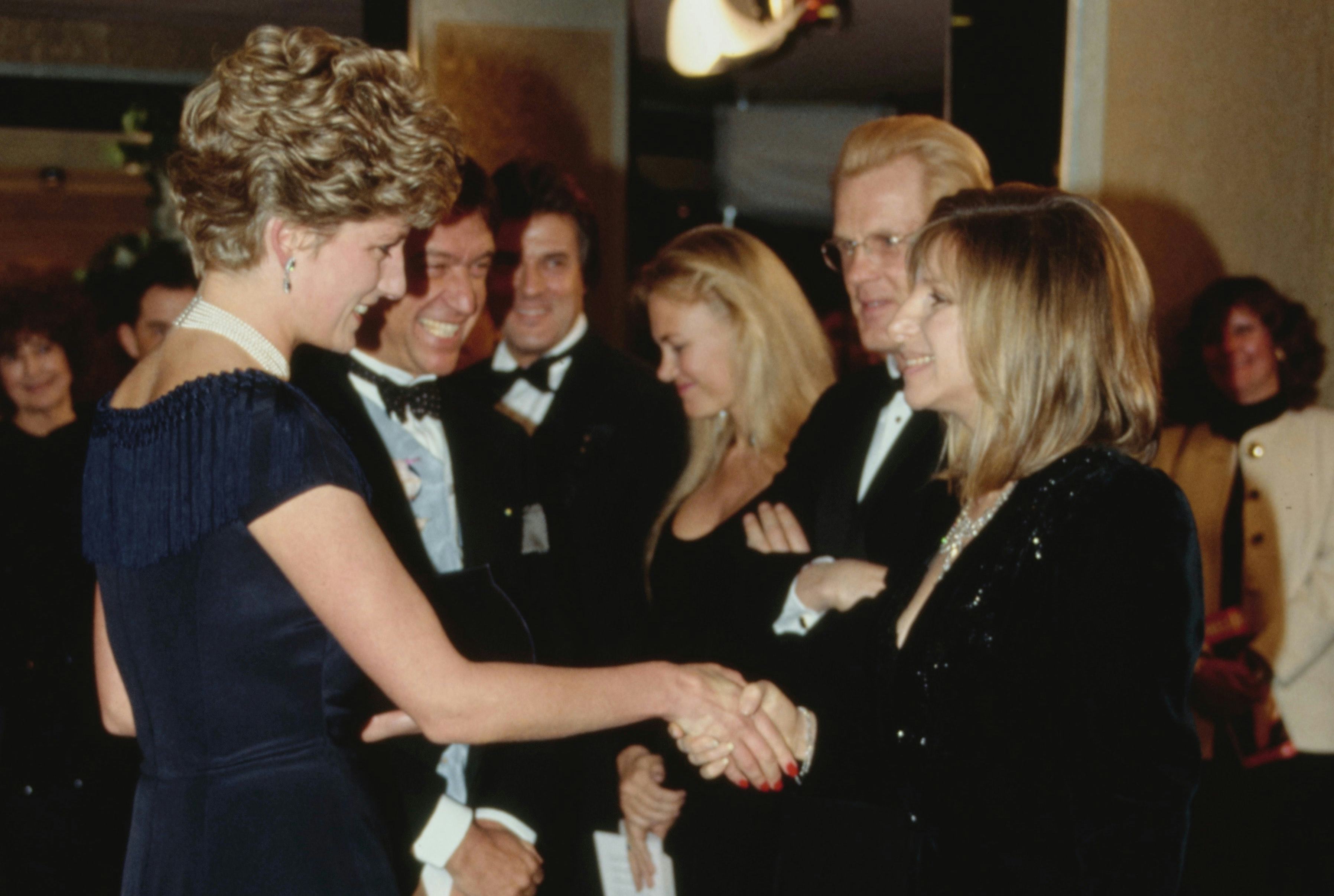 Princess Diana shaking hands with Barbra Streisand in London.