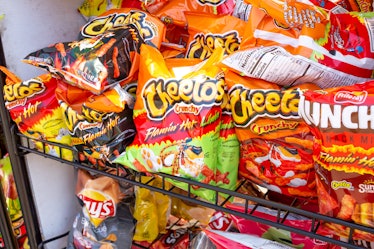 Spicy junk food on a shelf, including Flamin' Hot Cheetos.