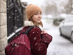 Young woman walking in winter snow during 2023's final Mercury retrograde on December 13.